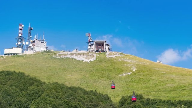 Scenic view of red cable car climbing mountain time lapse, mountain transport infrastructure, zoom to mountain top station