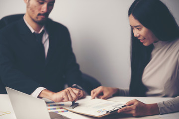 Close-up Of A Person's Hand Stamping With Approved Stamp On Document At Desk