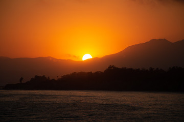Naklejka premium Sunset, Santa Barbara, California, Rincon Beach, sea, pacific ocean, orange, mountains, sun behind mountains