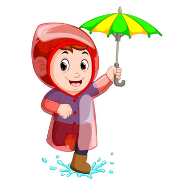 Little boy wearing raincoat and holding umbrella