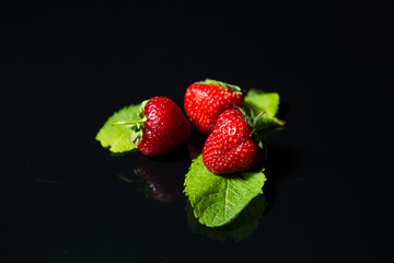 ripe red strawberries on a black background