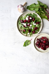 Healthy beet salad with goat cheese and arugula. Concrete background with copy space. 