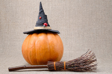 Broom and hat of  witch on a pumpkin for Halloween