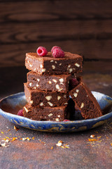 Homemade dark chocolate brownies topping with almond and raspberry in a plate