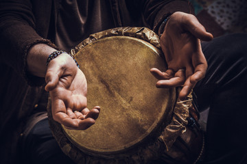 Ethnic percussion musical instrument jembe and male hands