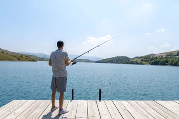 Fotobehang Achteraanzicht man vissen op het meer, op zonnige dag © phoenix021