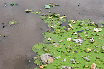 The waste junk falls into the stream. Polluting public water. The lack of a system and lack of discipline in waste management in urban areas in underdeveloped countries.