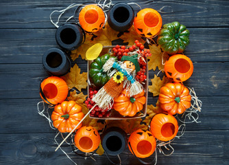box with pumpkins, rowan, leaves, scarecrows on the dark background. Halloween concept, decoration