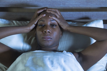 young scared and stressed black african American woman depressed on bed upset unable to sleep...