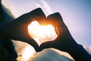 people hands making heart shape in sky