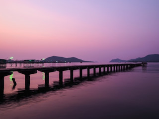 Fototapeta na wymiar Local pier at sunrise or sunset background in Thailand. Wooden bridge at twilight purple sky.