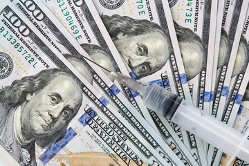 Syringe lie on american dollars banknote.