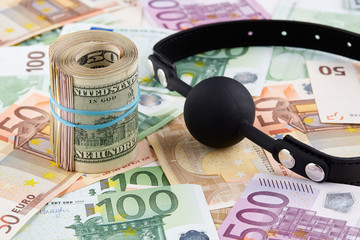 Black gag and roll of american dollars on euro banknotes