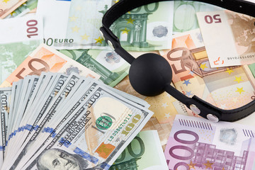 Black gag and heap of american dollars on euro banknotes