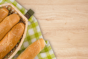 Buns in a wicker basket on old wooden table.