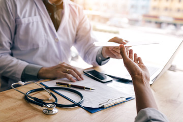 Doctor hand giving prescription document to patient.