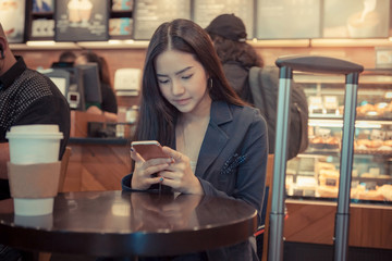Photo businesswoman wearing suit, touching smartphone screen and smiling.