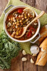 Stewed kale cabbage with chickpeas and vegetables close-up. Vertical top view