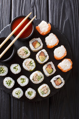 Set Japanese rolls assortment maki, uramaki, hosomaki are served on a stone board. Vertical top view