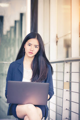 Beautiful business woman sitting on suitcase.