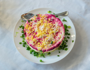 Herring under a fur coat on a table