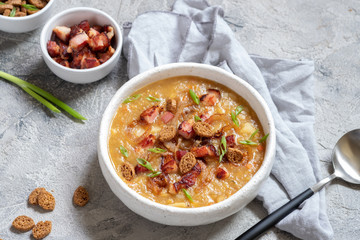 Lentil pea soup garnish with bacon, onion and croutons.