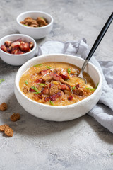 Lentil pea soup garnish with bacon, onion and croutons.