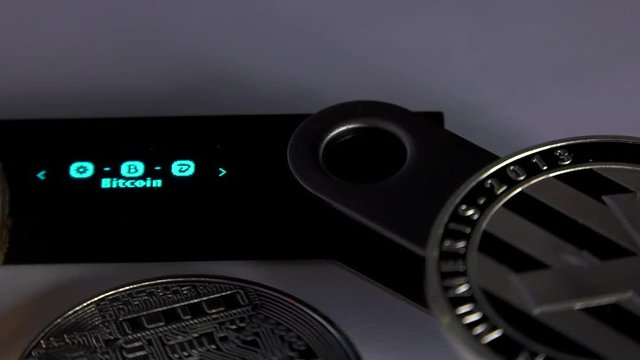 Crypto Currencies Cold hardware wallet lying with golden bitcoin coins. White background, Closeup,
