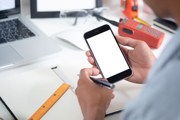 Man holding mockup smartphone on white table office workspace.