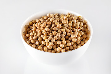 Closeup bowl of uncooked chickpeas isolated at white background.