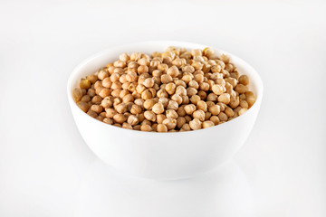Closeup bowl of uncooked chickpeas isolated at white background.
