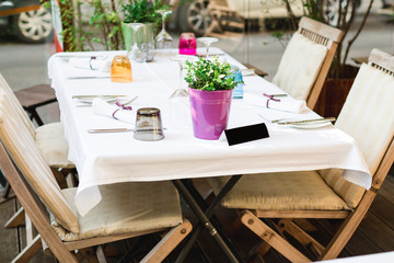 Cafe terrace in small European city. Beautiful terrace or balcony with small table, chair and flowers.
