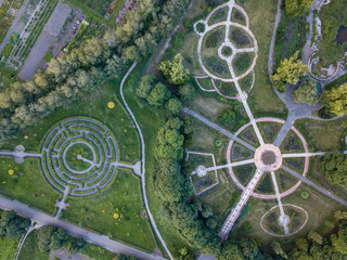 Birds eye view from the drone to a Garden labyrinth and park alleys of the round form in the park.