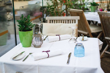 Cafe terrace in small European city. Beautiful terrace or balcony with small table, chair and flowers.