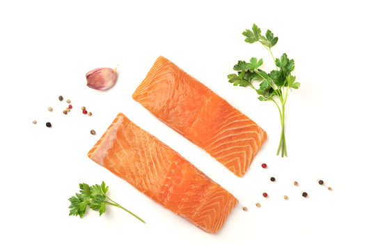Slices of salmon with parsley, garlic and pepper, on a white background with copy space, overhead photo