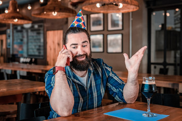 Obraz premium Emotional man. Birthday man feeling very emotional and depressed while speaking on the phone with friend
