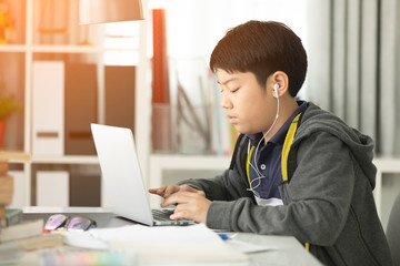 Fototapeta premium Asian cute boy using laptop computer.