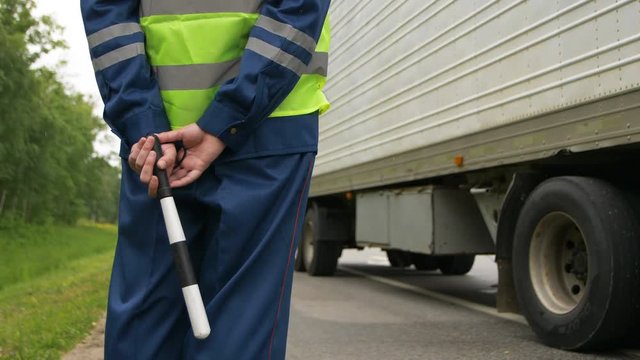backside view road police officer controls lorry driving past