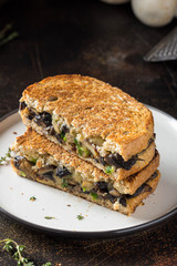 Hot sandwich with mushrooms, cheese and green onions, delicious lunch, autumn food. Dark background