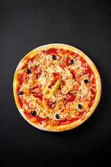 Hot italian pepperoni pizza on black concrete background, top view