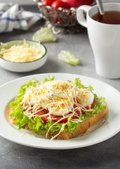 White bread sandwich with lettuce, tomato, boiled egg and grated cheese. Delicious lunch, healthy Breakfast on grey background
