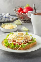 White bread sandwich with lettuce, tomato, boiled egg and grated cheese. Delicious lunch, healthy Breakfast on grey background