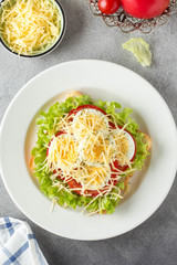 White bread sandwich with lettuce, tomato, boiled egg and grated cheese. Delicious lunch, healthy Breakfast on grey background