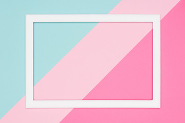 Abstract geometrical pastel blue, teal and pink paper flat lay background. Minimalism, geometry and symmetry template with empty picture frame mock up.