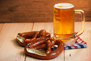 Pretzel with glass of beer on wood table for oktoberfest.