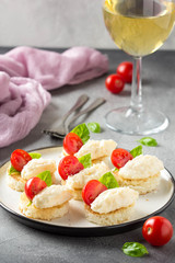 Canape with cheese mousse, cherry tomato and basil, small sandwich on crispy toast with cheese and garlic dumplings. Delicious appetizer, wine snack