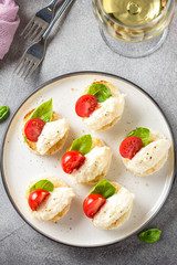 Canape with cheese mousse, cherry tomato and basil, small sandwich on crispy toast with cheese and garlic dumplings. Delicious appetizer, wine snack