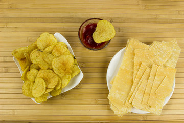 Chips on a plate. Wooden table. Salty food for beer
