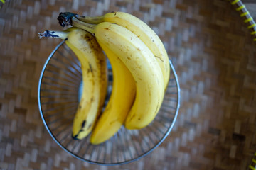 Bananas in basket on wooden zigzag plate