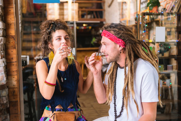Weekend in bar. Stylish fashionable hippie man and woman drinking tequila spending weekend in bar